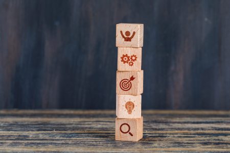 Business strategy concept with wooden cubes on wooden and grunge background side view.